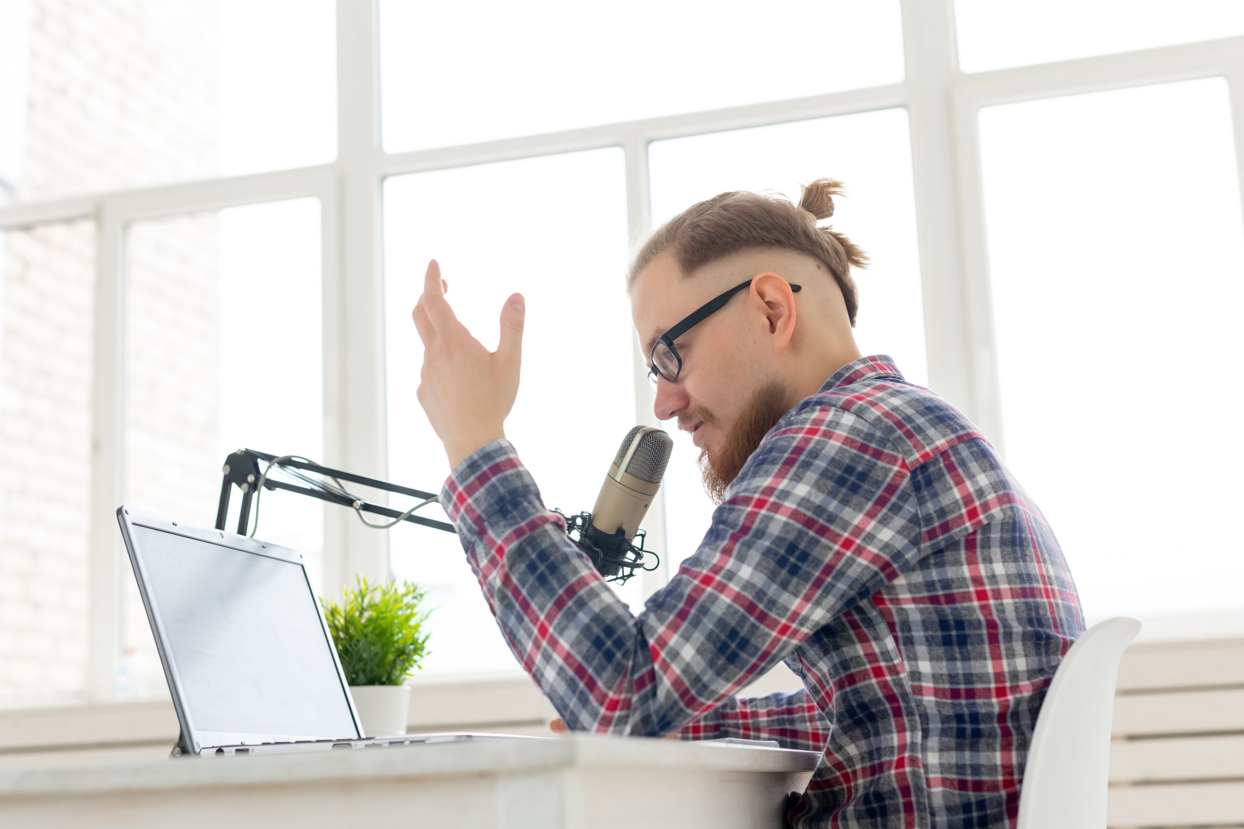 Radio, DJ, blogging and people concept - Smiling man sitting in front of microphone, host at radio